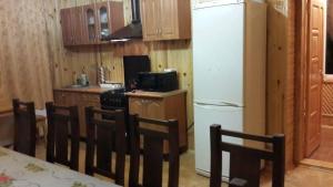 a kitchen with a table and chairs and a refrigerator at Holiday Home Rayskiy Ugolochek in Kvitki