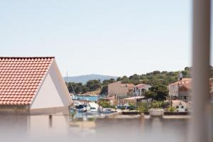 a house with a red roof on a body of water at Apartment Josip 2 in Tribunj