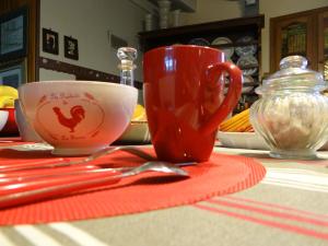 a red cup sitting on a table with a red napkin at Le Grillage a Poules in Gensac-la-Pallue +15 photos