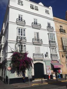 um grande edifício branco com uma pessoa de pé na frente dele em Casa Bugambilla Cadiz em Cádiz