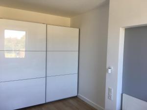 a white closet with a glass door in a room at Apartament Baltic Park - BEL MARE in Pogorzelica