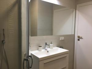 a bathroom with a sink and a mirror at Apartament Baltic Park - BEL MARE in Pogorzelica