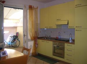 a kitchen with yellow cabinets and a sink at Bilocale centro storico in Pesaro
