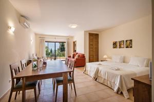 a hotel room with a bed and a table and chairs at Estrela da Luz Resort in Luz
