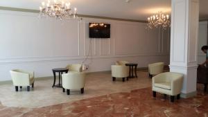 Zimmer mit Stühlen, Tischen und einem TV in der Unterkunft Olive Tree Hotel and Banquet halls in Jackson