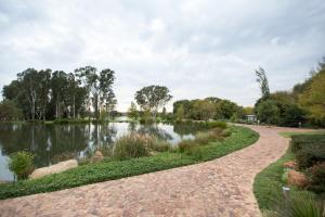 a path next to a lake in a park at Oxbow Country Estate in Bronkhorstspruit
