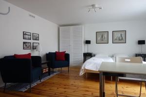 a bedroom with a bed and two chairs and a table at Villa Elisabeth Apartments in Pärnu
