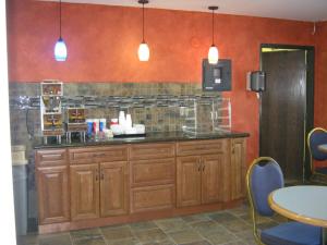 a kitchen with wooden cabinets and a counter top at Burnsville Inn & Suites in Burnsville