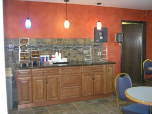a kitchen with wooden cabinets and a counter top at Burnsville Inn & Suites in Burnsville