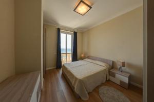 a bedroom with a bed and a large window at Blu Sea apartments in Pietra Ligure