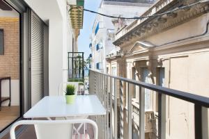 balcón con mesa blanca y sillas en Sweet Home Sitges BY BLAUSITGES, en Sitges