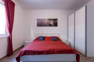 a white bedroom with a red bed with blue pillows at Luxury Villa ARIA, Apartment in Trogir +40 photos