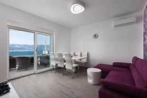 a living room with a purple couch and a table at Luxury Villa ARIA, Apartment in Trogir