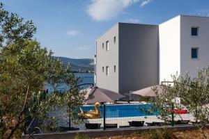 a swimming pool with a swan in front of a building at Luxury Villa ARIA, Apartment in Trogir