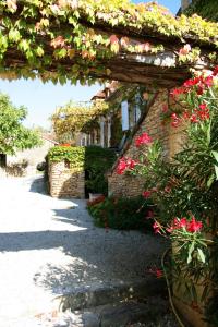 a garden with flowers and a brick building at La vignolle in Saint-Amand-de-Coly