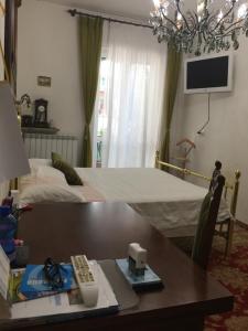1 dormitorio con mesa y 1 cama con TV en Sole, en Verona