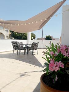 un patio con mesa, sillas y flores en Apartamento Villananitos, en San Pedro del Pinatar