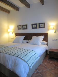a bedroom with a large white bed with two pillows at Refugio del Segura in Pontones