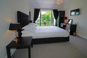 a bedroom with a bed and a desk and a window at Greyhound Hever in Edenbridge