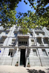 a large white building with a door in front at Hotel Dom Sancho I in Lisbon