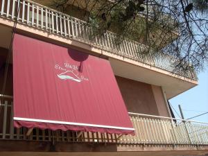 a red sign on the side of a building at Etna Inn in Motta SantʼAnastasia