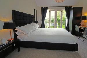 a bedroom with a large bed and a desk and window at Greyhound Hever in Edenbridge +13 photos