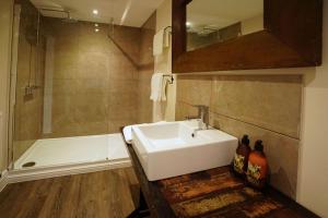 a bathroom with a sink and a bath tub at Greyhound Hever in Edenbridge