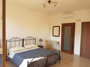 マルターノにあるBBda Fabioのベッドルーム1室(青い毛布と鏡付きのベッド1台付)
