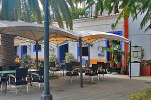 a patio with tables and chairs under an umbrella at La Casa del Abuelo in Los Sauces