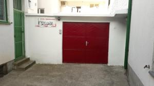 una puerta de garaje roja en el lateral de un edificio en Hostel Hercegovina en Mostar