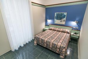 a bedroom with a bed and a blue wall at Le Petit Hotel in Turin