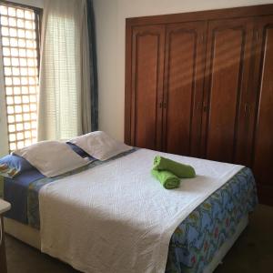a bed with a green stuffed animal sitting on it at Apartamentos La Mar in Altea