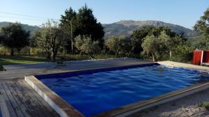 uma piscina com um deque de madeira e água azul em Quinta Do Vaqueirinho - Agro-Turismo em Marvão