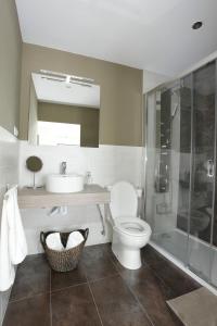 a bathroom with a toilet and a sink and a shower at vivienda vieja cepa in Noja