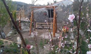 a stone cabin in a garden with flowers at Apartment Anetica in Cres