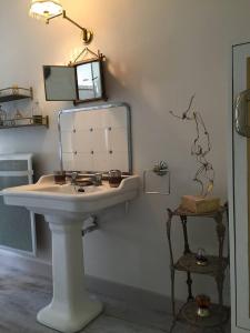 a bathroom with a white sink and a mirror at Domaine des Papeteries in Plounevez-Moëdec