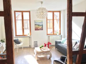 a living room with a couch and a table at Gîte Atelier de Hansi - Colmar Centre in Colmar