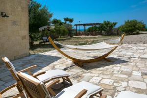 a couple of chairs and a hammock on a patio at Antica Masseria Ficazzana - Tenuta in Marina di Pescoluse