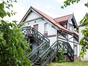 an old white house with a wooden stairway at Pokoje Inulec in Inulec