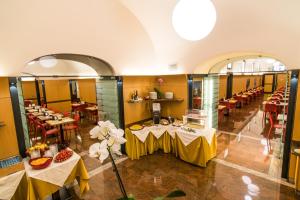 a restaurant with tables and chairs in a room at Le Petit Hotel in Turin