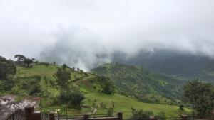 una collina verde con nuvole in cima di Nirvana Inn a Mahabaleshwar