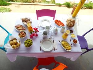 een roze tafel met eten en drinken erop bij Pousada Miau Miau in Icapuí