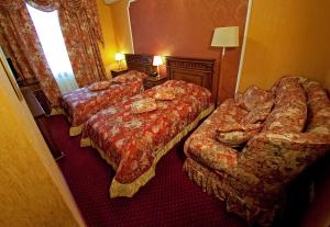 a hotel room with two beds and a couch at Deluxe Hotel Kupava in Lviv