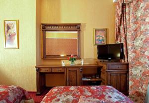 a bedroom with a television and a bed at Deluxe Hotel Kupava in Lviv