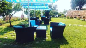 a group of chairs in the grass under an umbrella at Lumra Rooms in Lukovë