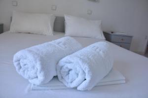 a bed with white towels on top of it at Paradise Studios in Myrtos