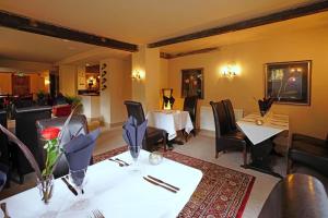 une salle à manger avec deux tables, des chaises et une table avec des fleurs dans l'établissement The Greyhound Inn, à Edenbridge