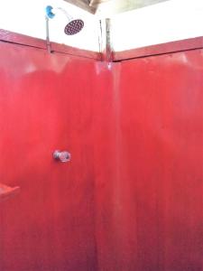 una parete rossa con una porta rossa con scarico di Lodge Jungle Wolf Expeditions a Yucuruche