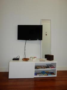 een witte tafel met een tv erop bij Oporto Downtown Apartment in Porto