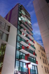un edificio de apartamentos alto con balcones rojos y verdes en Fraser Place Melbourne, en Melbourne
